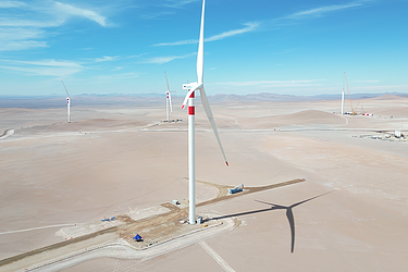 Photo of a wind turbine in the middle of a desert 