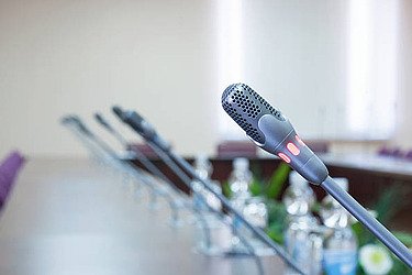 Photos of microphones lined up on a long table 