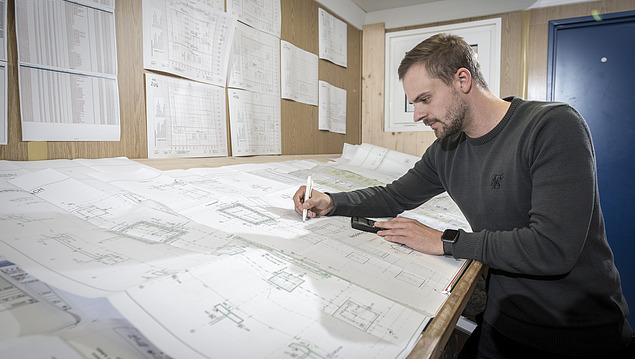 Photo of a man drawing an engineering plan