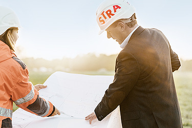 Photo of two construction workers looking at a building plan