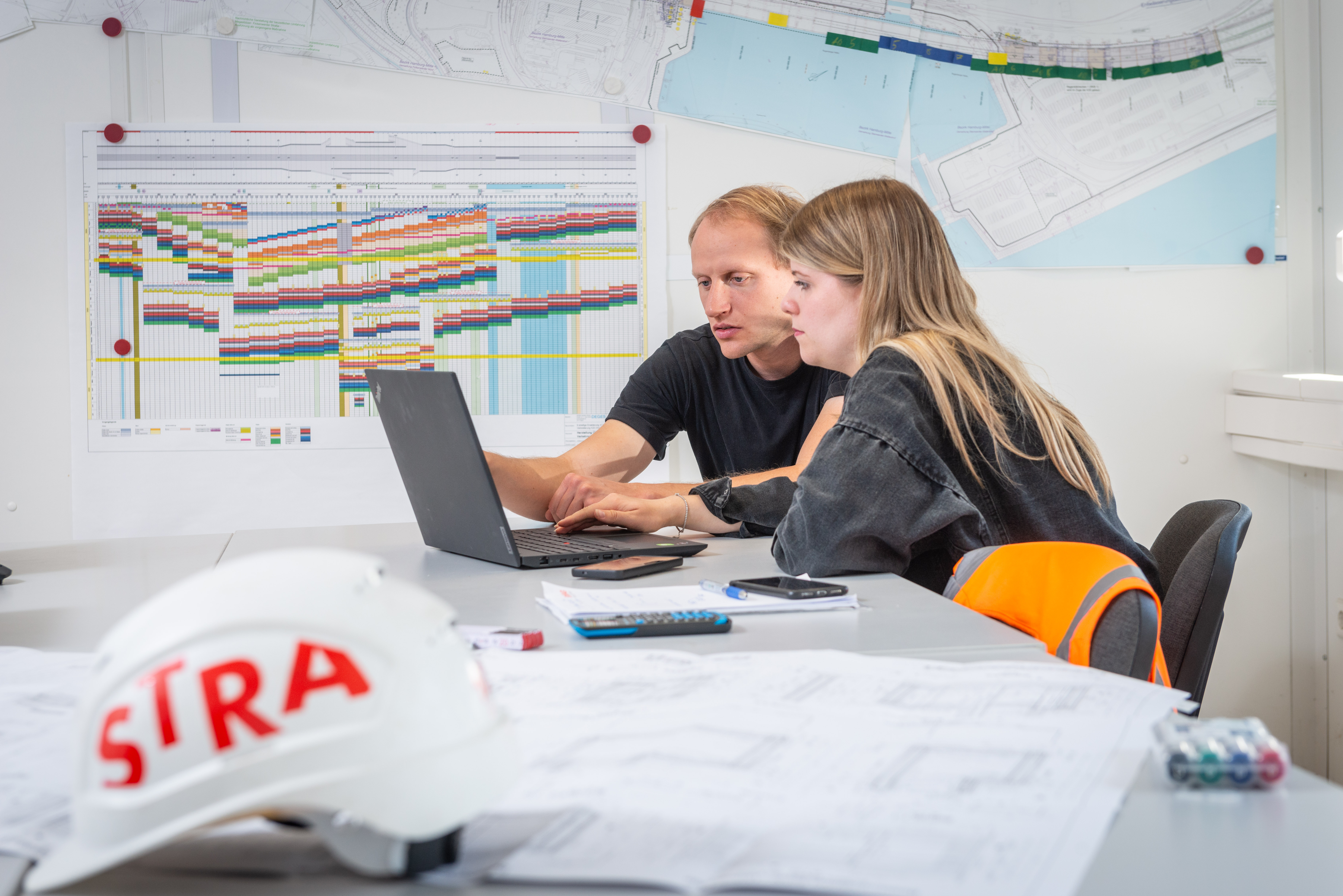 Photo of two employees working together on a laptop