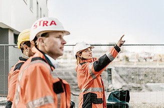 Photo of construction workers looking up at the sky