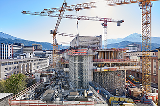 Foto einer Baustelle eines Hochauses mit drei Kränen 