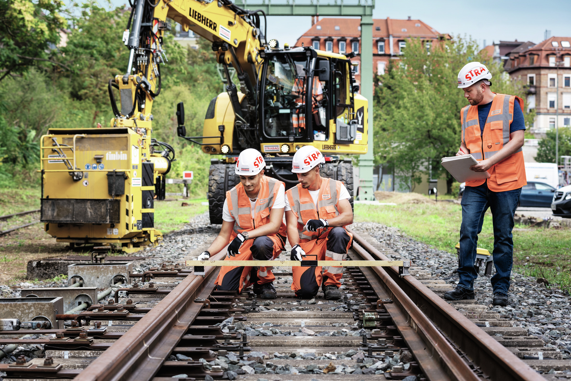 Foto von Wartungsarbeiten an Zuggleisen durch STRABAG Bauarbeiter