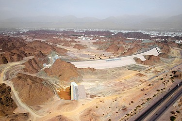 Foto eines Hochwasserschutzdamms inmitten einer Wüstenlandschaft im Oman 