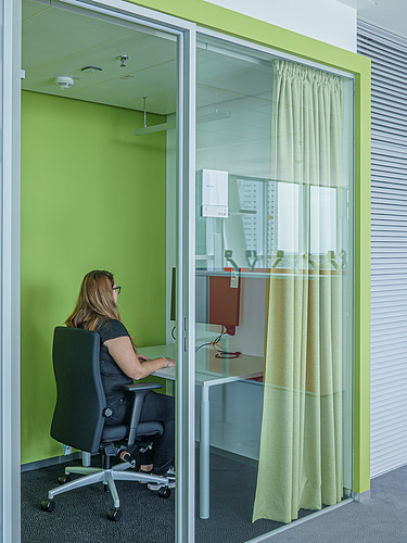 Foto von Mitarbeiterin in Telefonbox im STRABAG Büro Wien