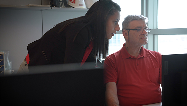 Photo of two STRABAG employees looking at something on a screen