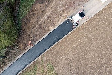 Vogelansicht von einer Straße, die asphaltiert wird 