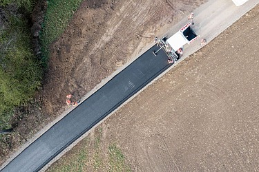 Bird's eye view of a road being asphalted 