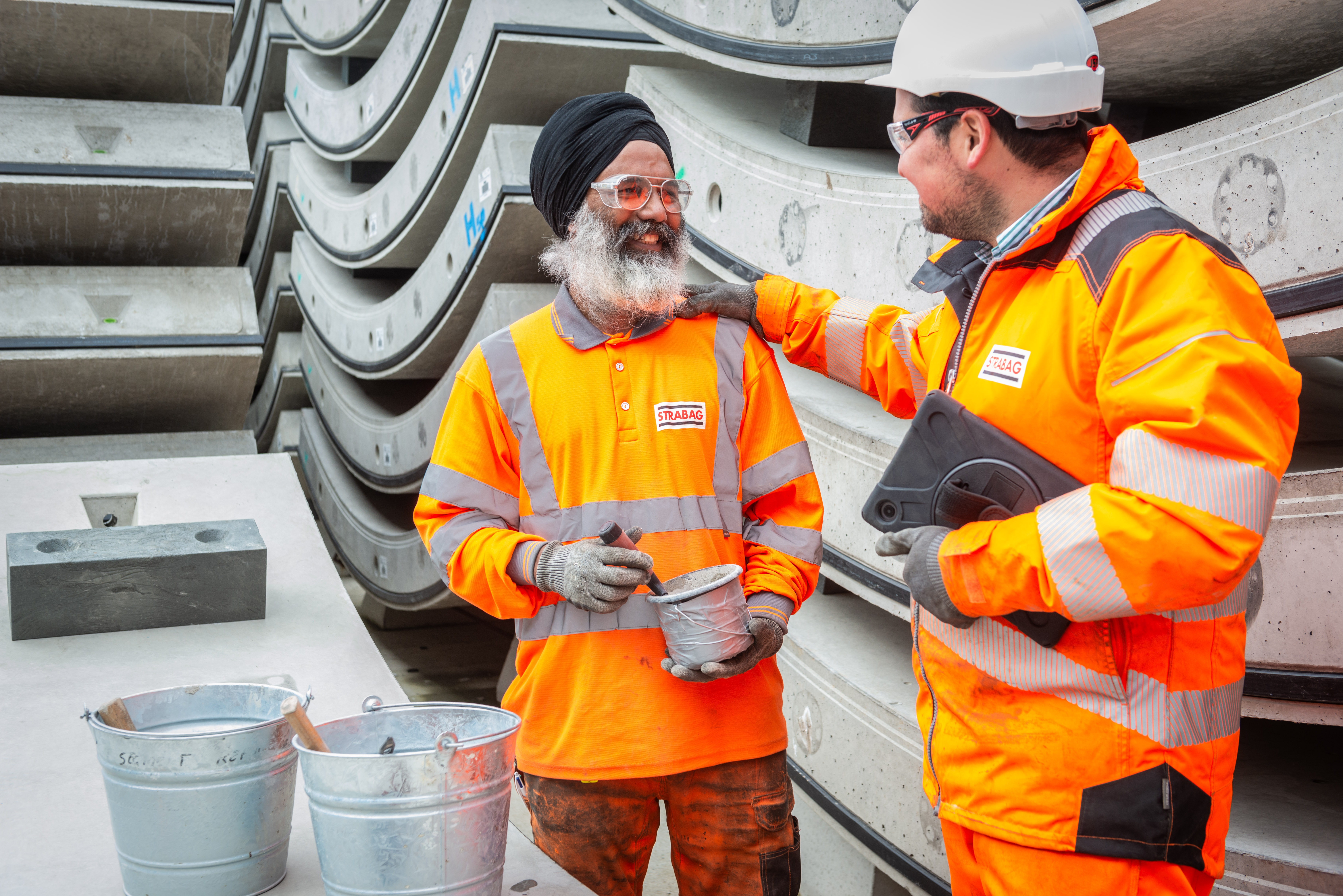 Photo of two construction workers of different ethnic backgrounds working together to